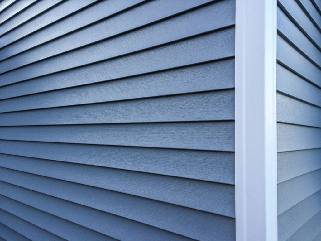 Blue vinyl siding with white trim on the outside wall of a new h